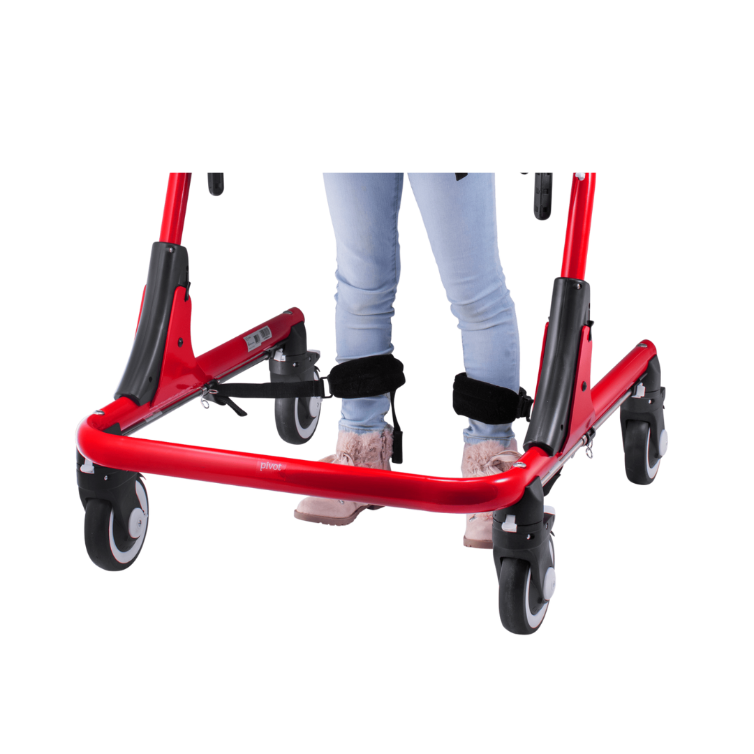 A person in light blue jeans and pink shoes uses Ankle Prompts For Pivot Gait Trainer, shown from the waist down against a white background.